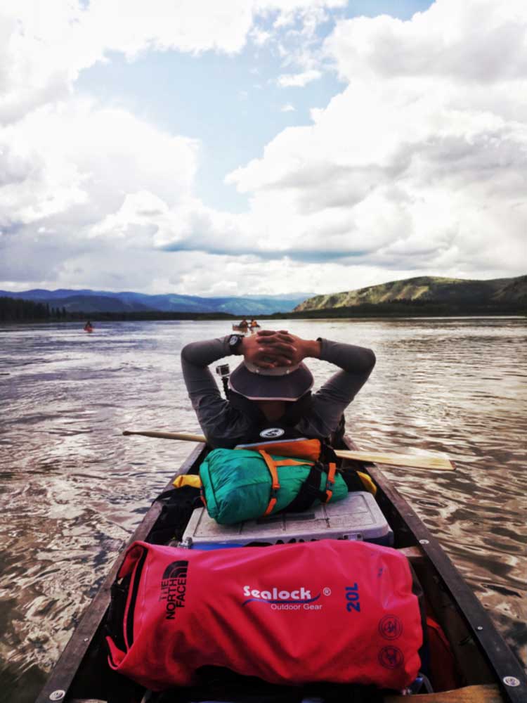 Kayak with waterproof dry bags lashed under deck bungees and in the tank well